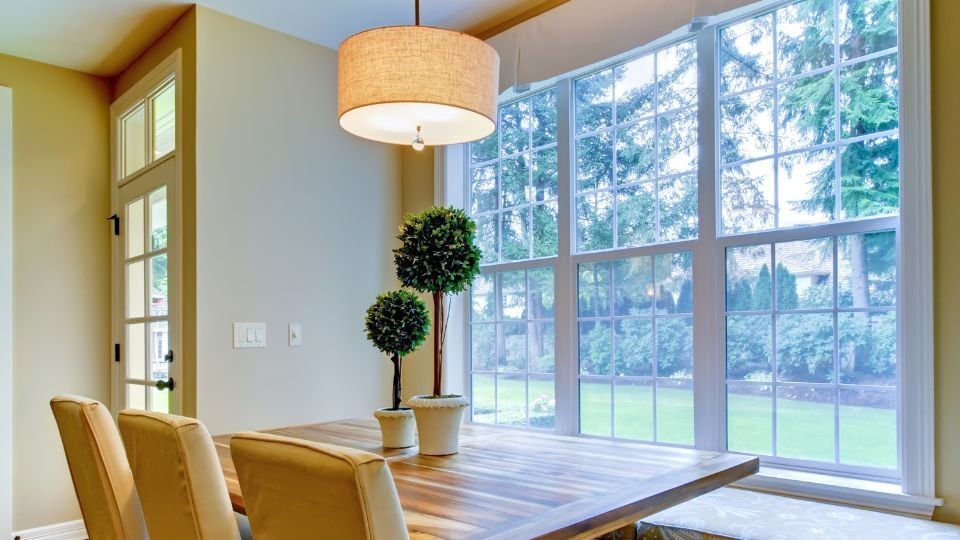 Kitchen table with white double hung windows with grids