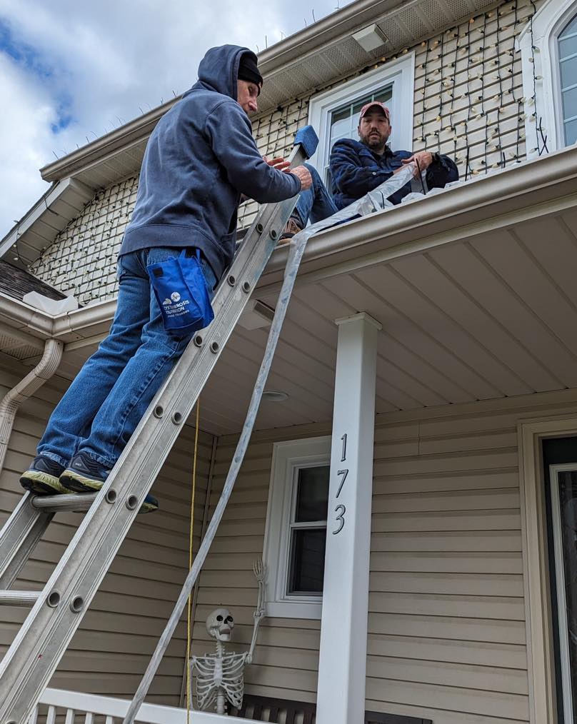 Randy and Greg putting lights on the roof